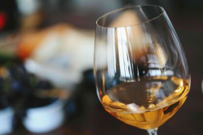 Glas gefuellt mit Weisswein