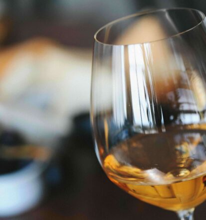 Glas gefuellt mit Weisswein
