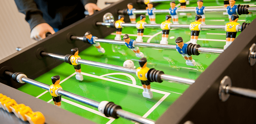 Menschen spielen Tischfussball in der Suchtberatung Holzminden