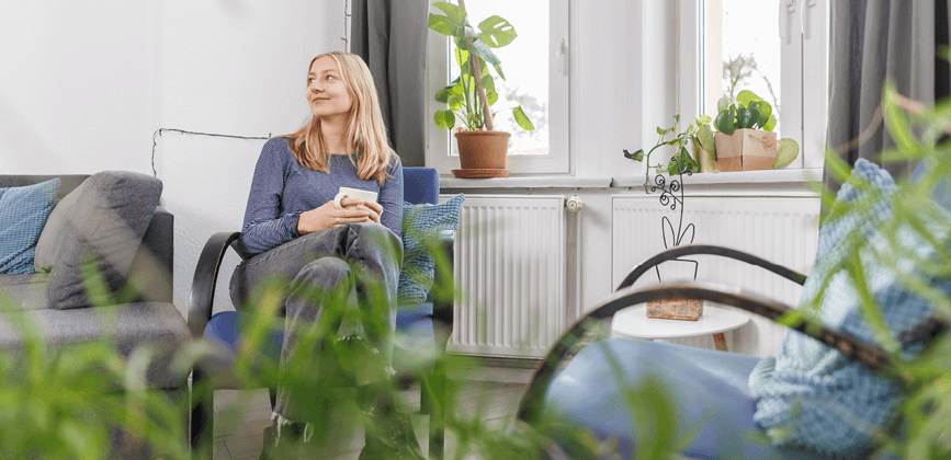 Klientin trinkt Kaffee und schaut positiv in den Raum