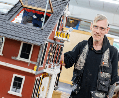 Bewohner präsentiert sein selbstgebautes Puppenhaus